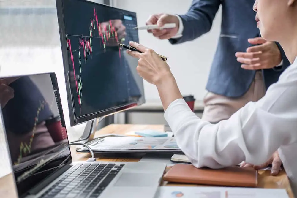 Business team partner working with computer, laptop, discussion and analyzing graph stock market trading with stock chart data planning, financial and investment concept.