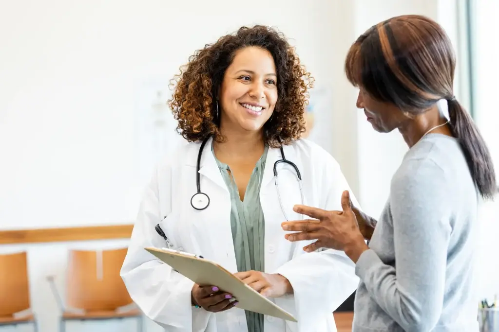 Female doctor and patient talking; healthcare, medicine, consultation.